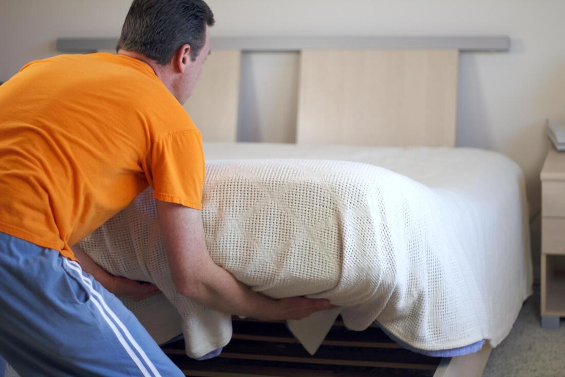 man changing mattress of bed